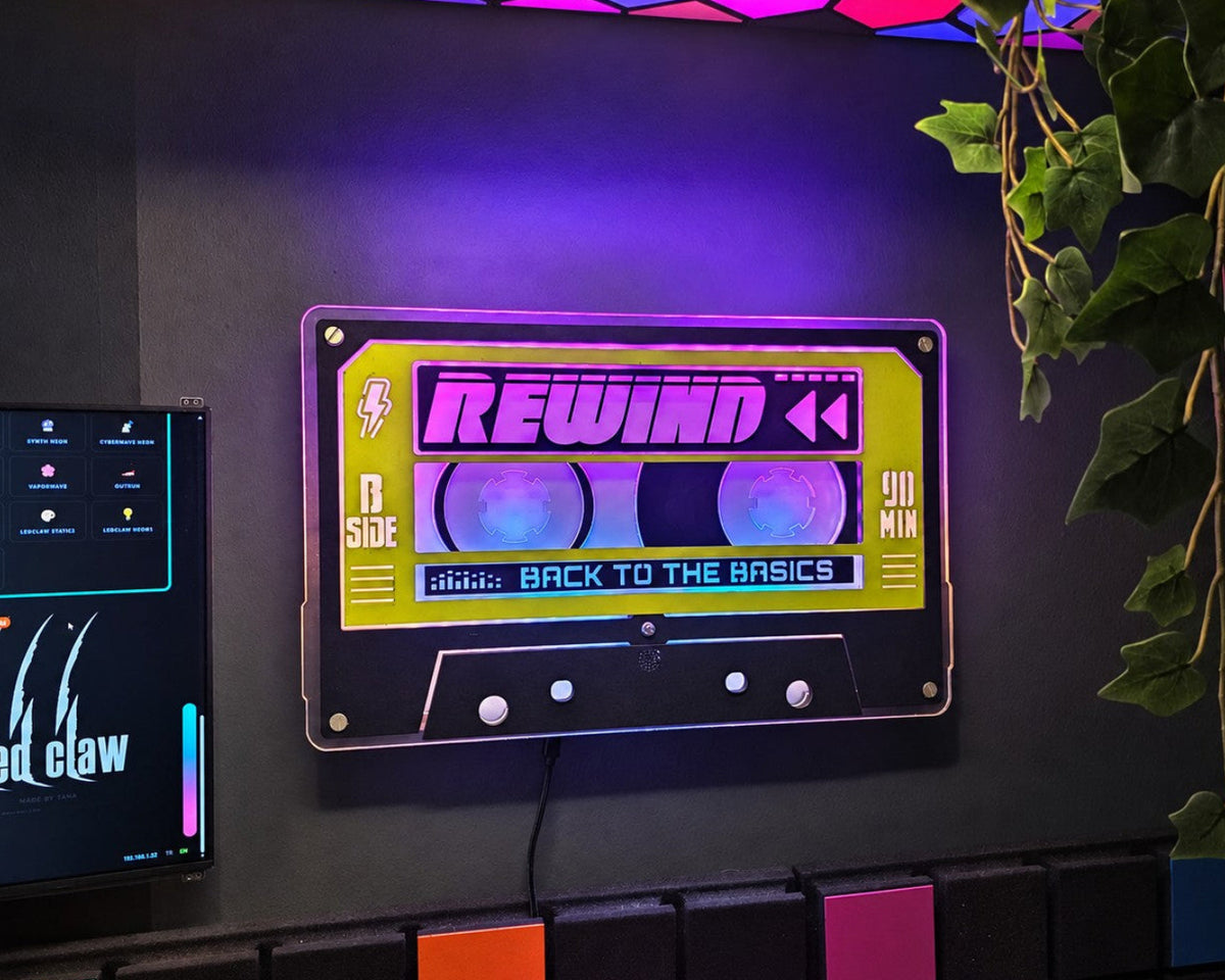 Handmade REWIND light-up cassette glowing purple on a dark wall